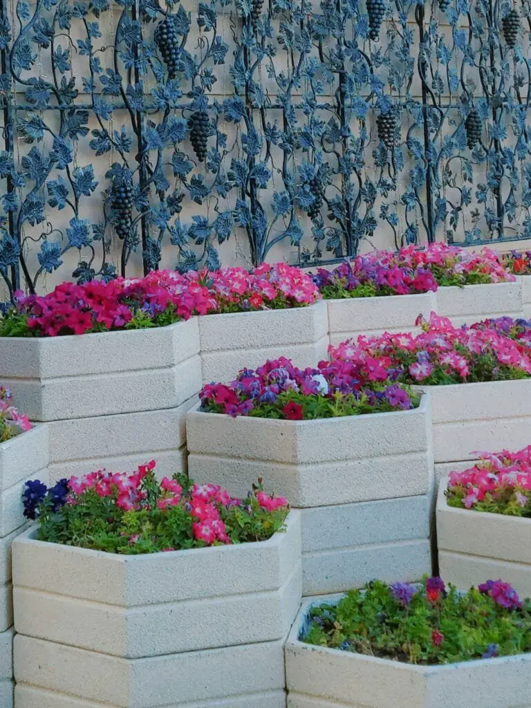 Come Progettare un Giardino da Zero Senza Esperienza 9 Aiuole modulari in cemento con fiori misti a gradoni davanti a parete decorativa