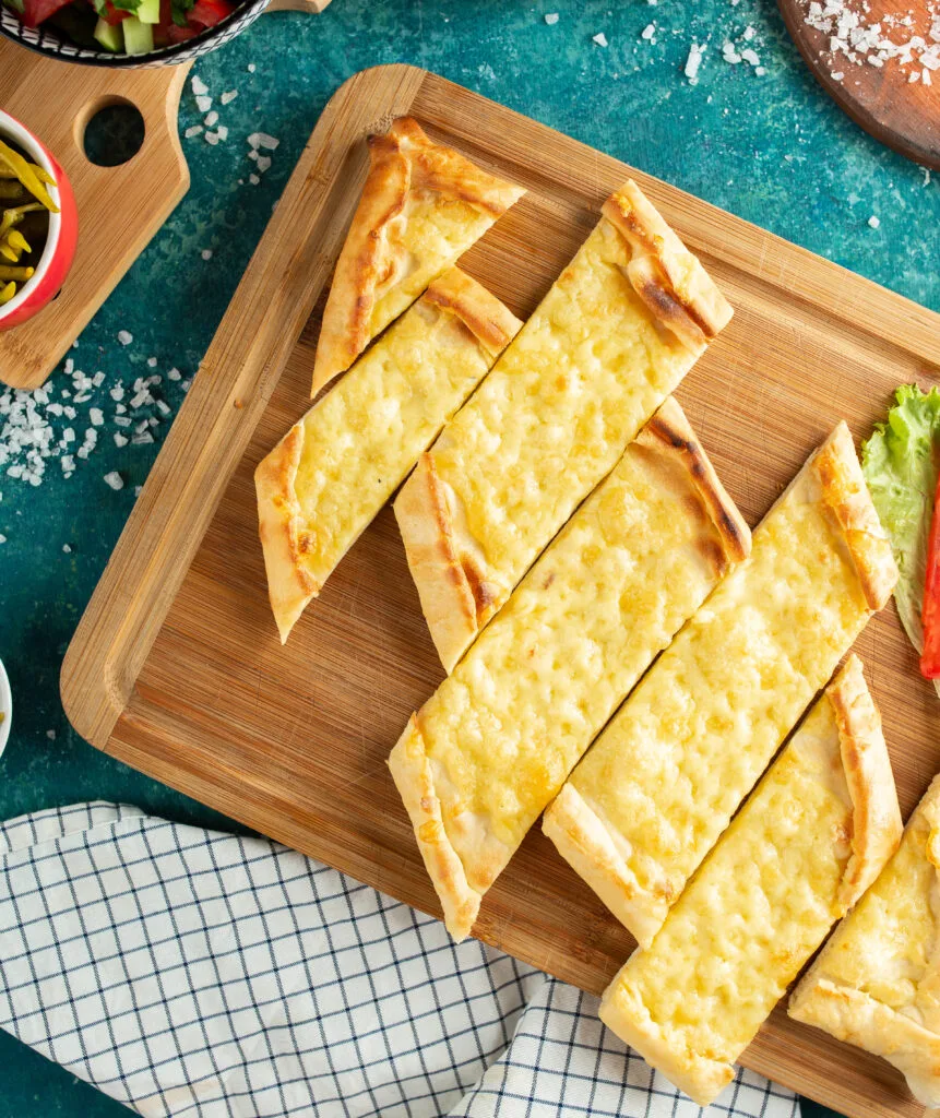 Pide al Formaggio: Ricetta Focaccia Turca Originale 1 a mia pide al formaggio appena uscita dal forno, tagliata a fette sul tagliere.