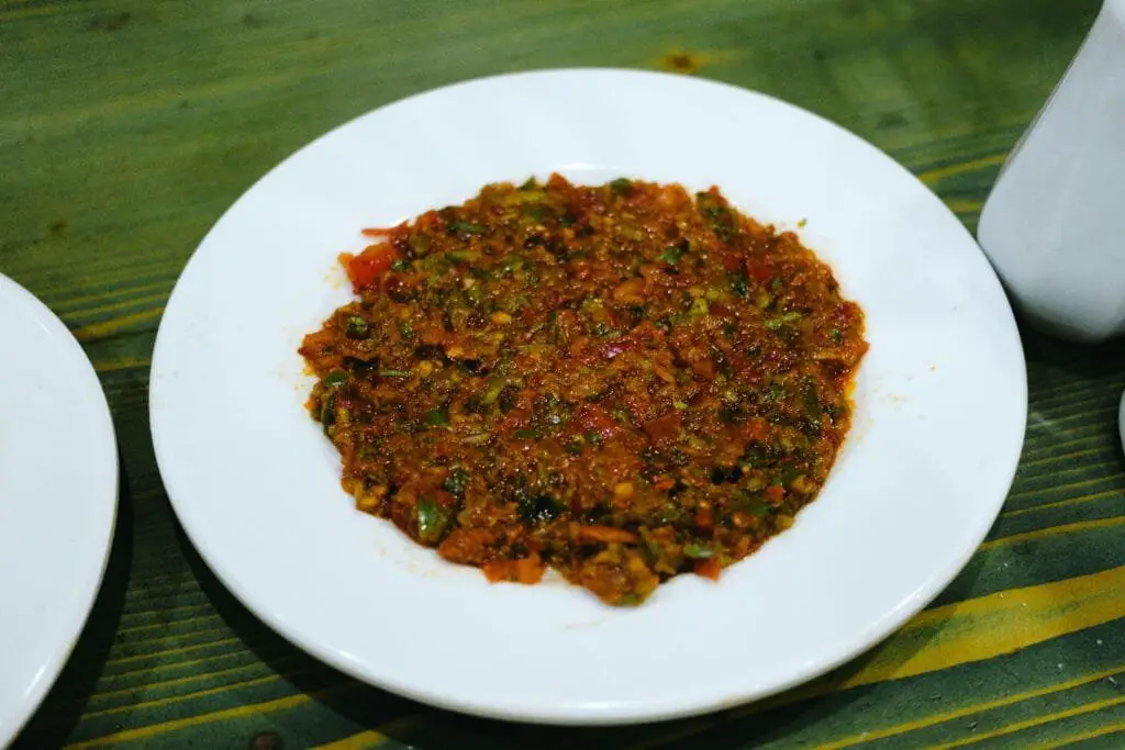 Ricetta Acili Ezme Turca: Salsa Piccante Fatta in Casa 3 Piatto di acili ezme turca pronta da servire con pomodori, peperoncini e prezzemolo tritati