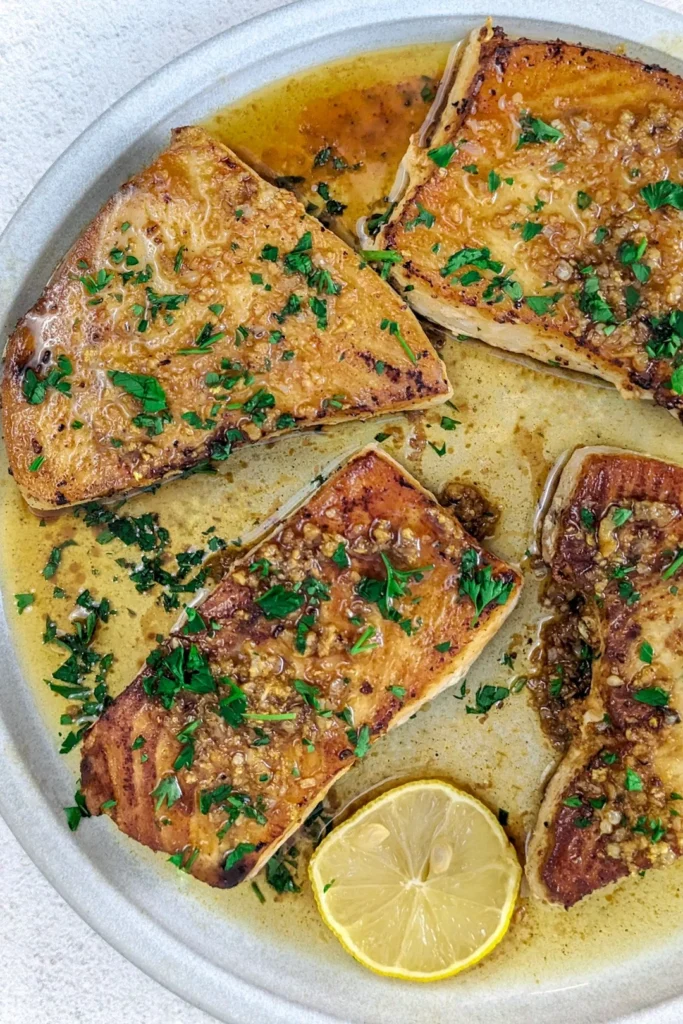 Salmoriglio Siciliano: Ricetta, Usi e Ingredienti Freschi 1 Fette di pesce spada grigliato, appena condite con abbondante salmoriglio preparato con limone, prezzemolo fresco raccolto dall’orto e aglio tritato. È il piatto che porto in tavola quando voglio sentire i profumi della Sicilia, semplice e genuino.