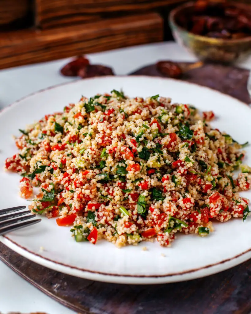 Kisir: Piatto Turco Con Bulgur e Verdure di Stagione 1 Un piatto di kisir appena preparato, con bulgur fine, pomodoro, prezzemolo e verdure fresche, servito su un piatto bianco.